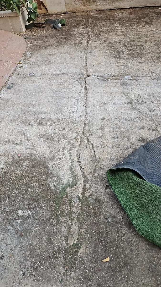 Hormigón agrietado de un parque infantil de Dénia antes de instalar césped artificial