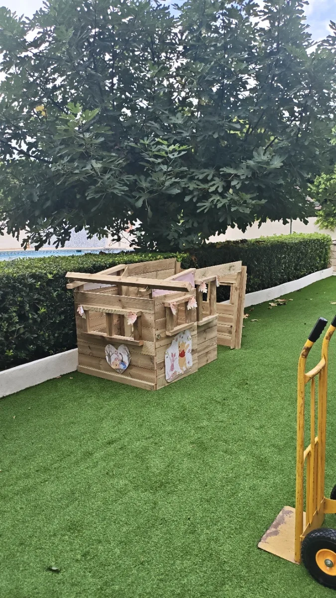 Montaje de la casita de madera sobre el césped artificial del parque infantil en Dénia