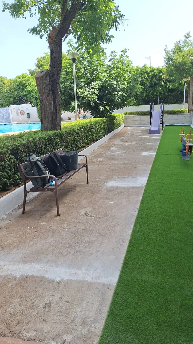 Instalación de césped artificial en curso en un parque infantil de Dénia, junto a la solera de hormigón